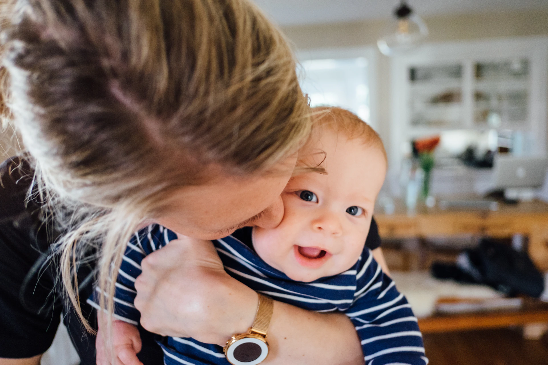 A parent holding a smiling baby.